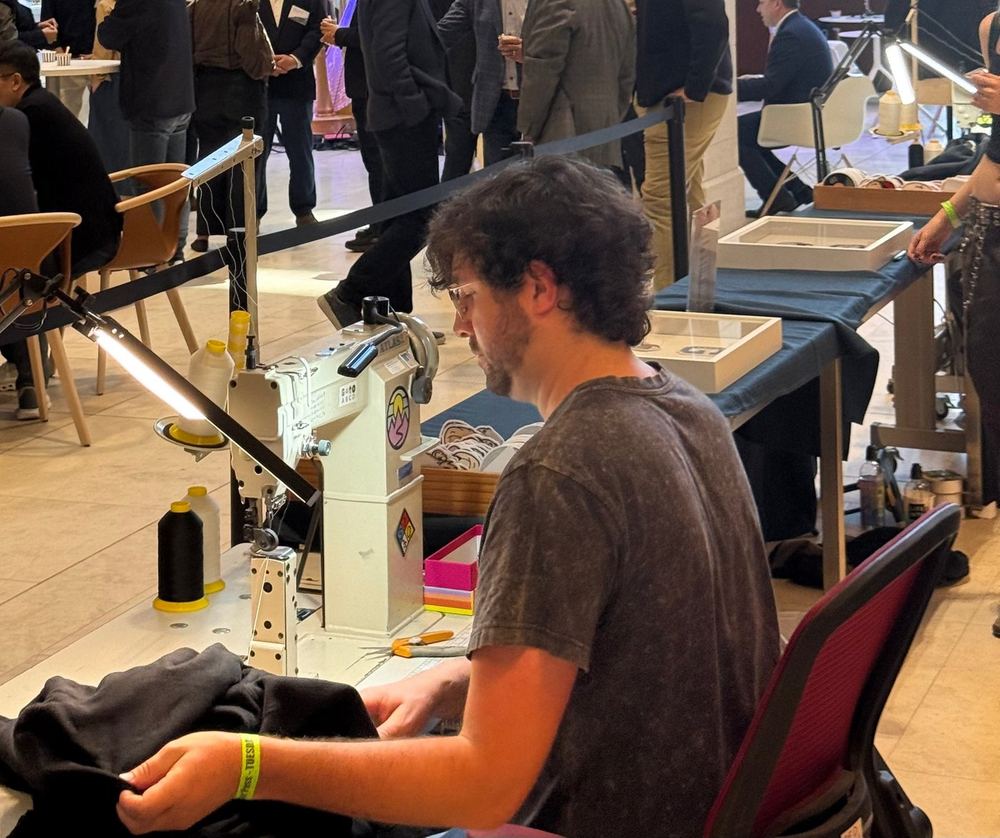Sewing a patch onto a hat at a live Patch Bar