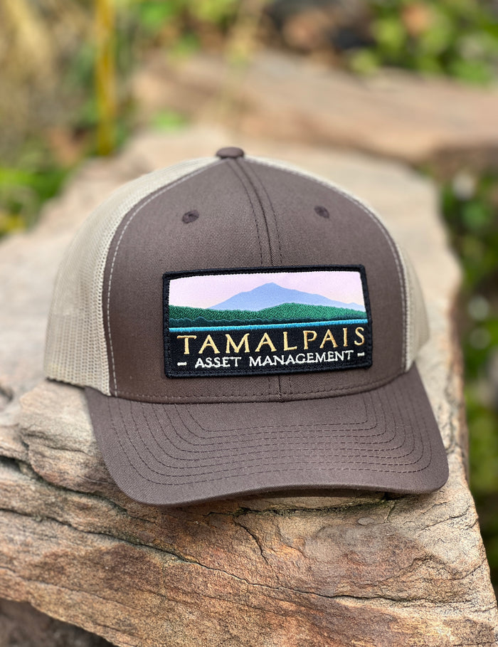 Finished custom patch trucker hat on a rock