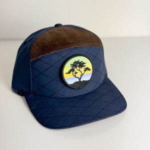 Navy blue cap with brown visor and tree emblem on a white background