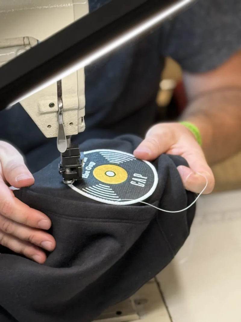 Needle stitching a round patch onto a hoodie